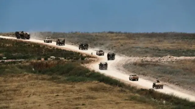 Israeli military vehicles on the Lebanese side of the border, seen today from northern Israel
