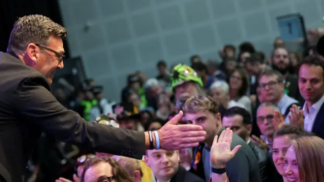 Burnham holds his hand out to high-five a member of the crowd