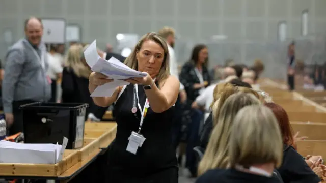 An election worker handles ballots for counting in the Makerfield by-election.