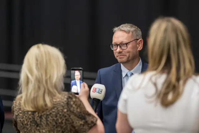 SNP candidate Richard Gordon Thomson gives an interview - a journalist holds up an LBC microphone