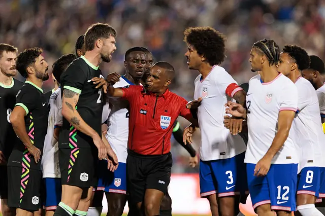 Referee Kwinsi Williams breaks up an argument between Cameron Burgess of Australia and Chris Richards #3 of the United States during a friendly match in October 2025 in Colorado