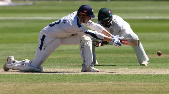 James Wharton plays a sweep shot past a close-in fielder