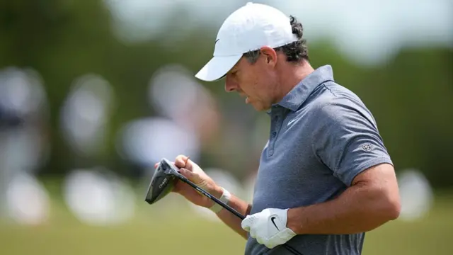 Rory McIlroy cleans his club