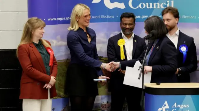 Lara Bird (second left) is congratulated by the presiding officer. Three other candidates stand near her