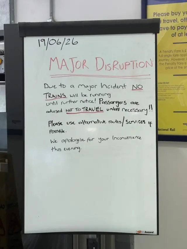 A whiteboard with passenger info in black, headlined "MAJOR DISRUPTION" in red.
