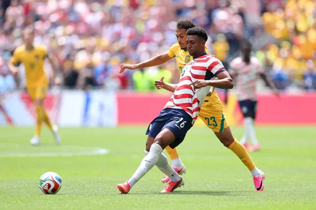 Alex Freeman passes the ball under pressure from Nishan Velupillay