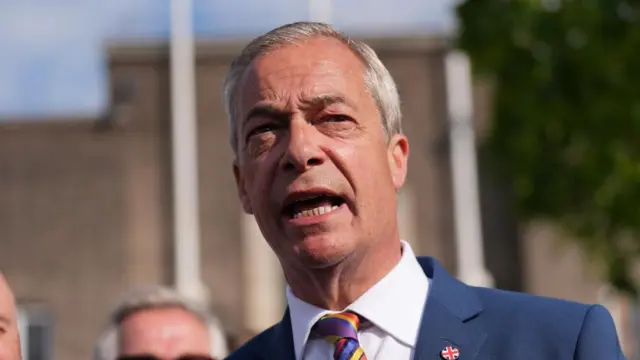 Farage speaks outside at an event.