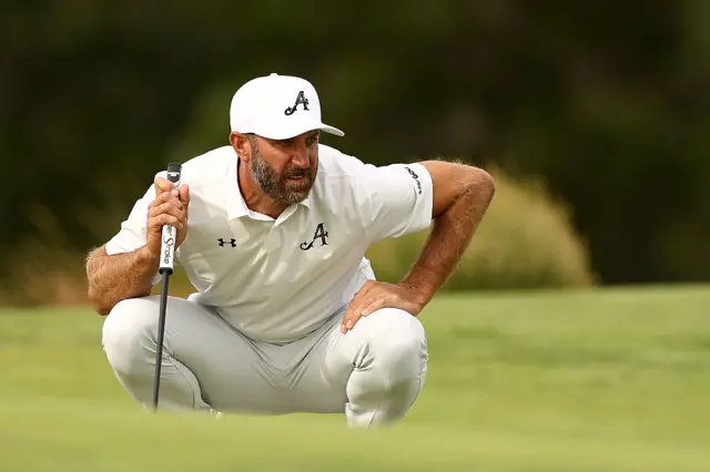 Dustin Johnson examines the green