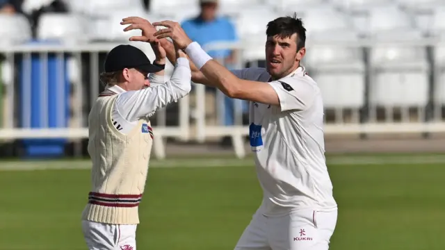Craig Overton high-fives a Somerset team-mate as he celebrates taking a wicket against Nottinghamshire