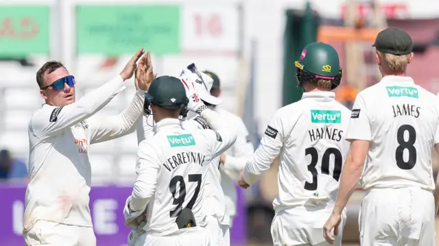 Liam Patterson-White (left) is congratulated by his team-mates for taking an Essex wicket