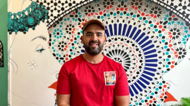 Ayoub Nadir, looking at the camera and wearing a red t-shirt
