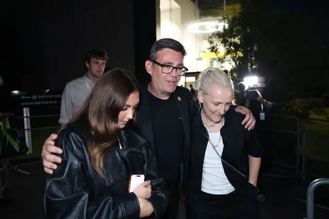 Burnham with his arms round his daughter and wife