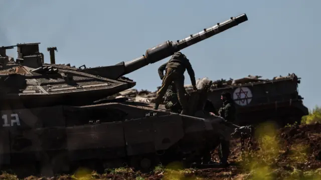 Israeli tanks are deployed at a military outpost along the border with Lebanon