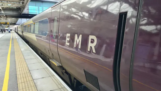 An EMR purple train seen at a platform