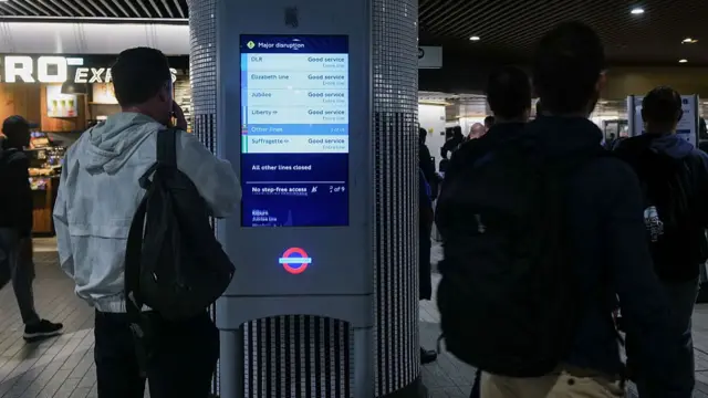 At Liverpool Street Station, a man reads an information board showing disruption to Tube networks