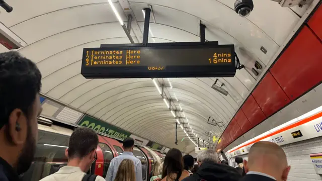 Commuters walk down the platform after getting off the central line at Liverpool Street underground station