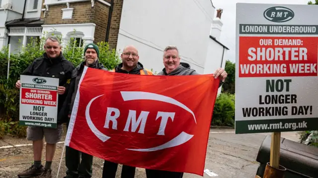Protestors hold RMT red banner
