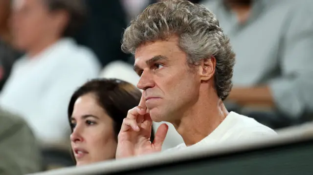 Gustavo Kuerten watches a tennis match
