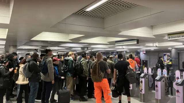 A large number of people at the ticket barrier at Victoria station