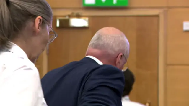 Peter Murrell is led from the dock