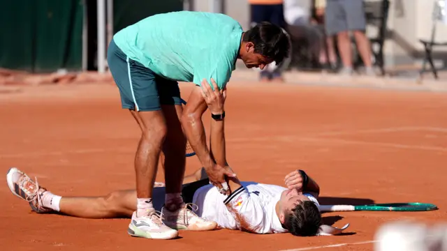 Jakub Mensik lies on the court while suffering with cramp