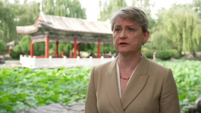 Yvette Cooper stands in a garden in China