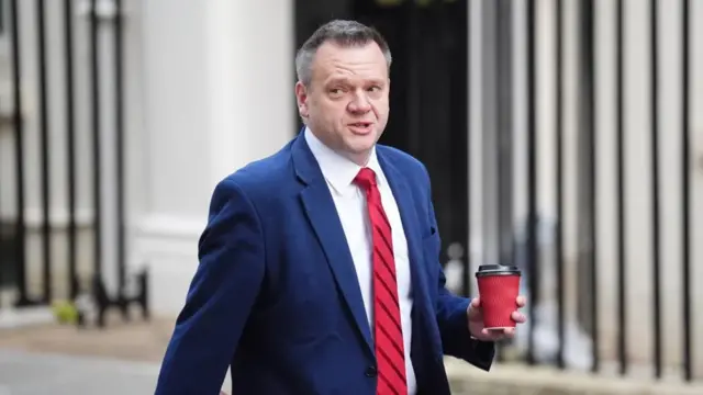 Nick Thomas-Symonds walks out of Downing Street holding a coffee