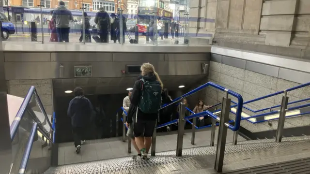 Passengers walk down stairs at Victoria underground station