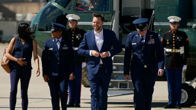 JD Vance walks surrounded by officials