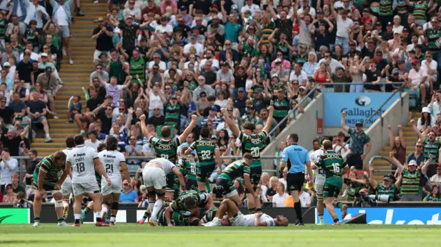 Northampton players celebrate try in front of crowd