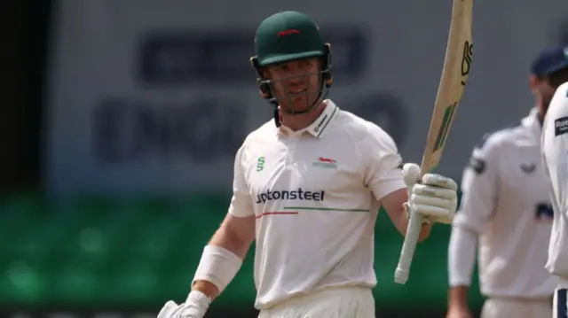 Nick Kelly raises his bat in celebration against Yorkshire