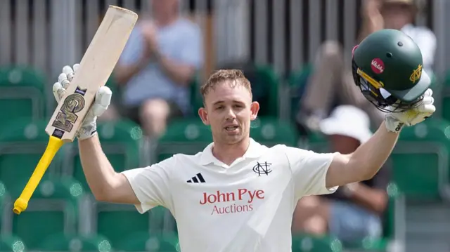 Jack Haynes raises both arms ip to salute his century