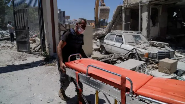 A rescuer prepares a stretcher at the site of an Israeli air strike on a house in Barish, Tyre district, southern Lebanon, 20 June