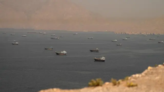 Vessels waiting at the Strait of Hormuz in between land with a hazy view