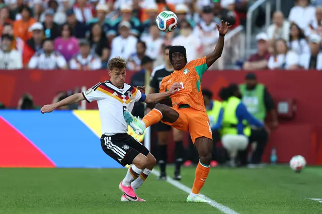 Joshua Kimmich fights for the ball with Yan Diomande