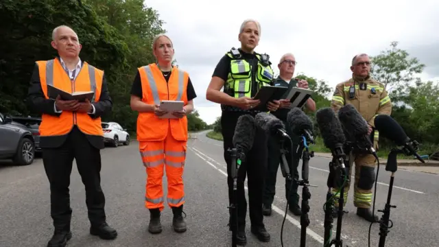 Two women and three men speaking into microphones.