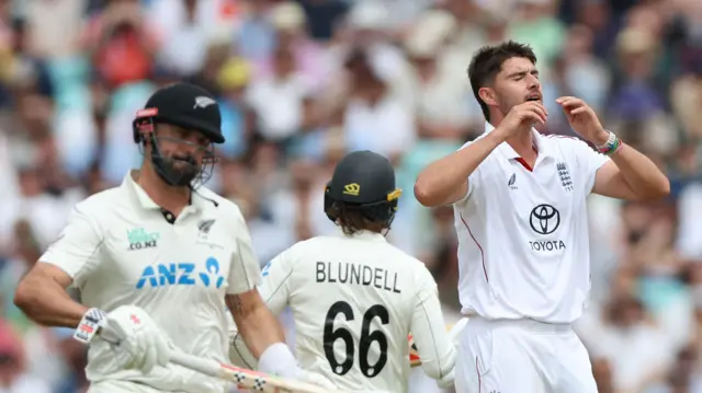 Daryl Mitchell and Tom Blundell batting for New Zealand and Josh Tongue has his hands on his heads bowling for England