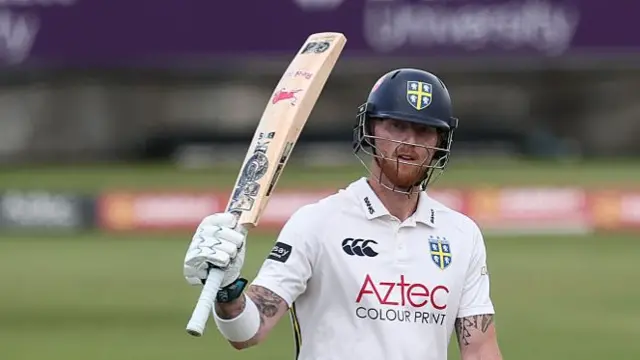 Ben Stokes raises his bat to acknowledge reaching 50