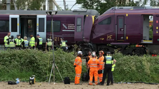 The site of the crash. Police and other people in high-vis stand nearby