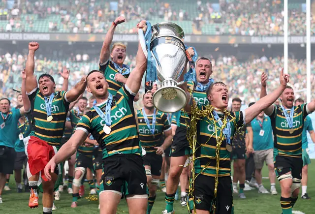 Saints plays celebrate with a large trophy
