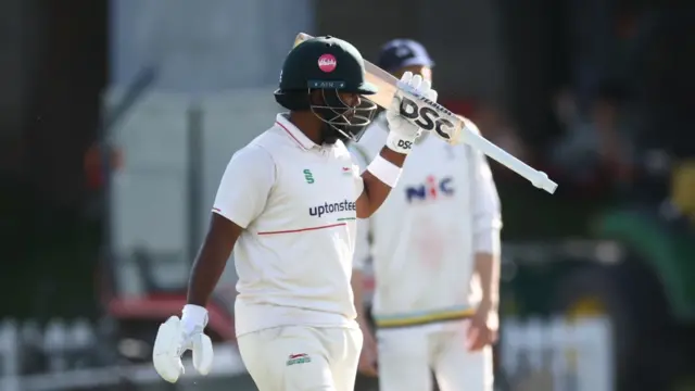 Rehan Ahmed raises his bat to the crowd during the match against Yorkshire