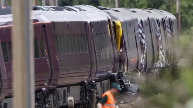The train crash as pictured from the side. The shape of some of the carriages appear to be distorted by the impact