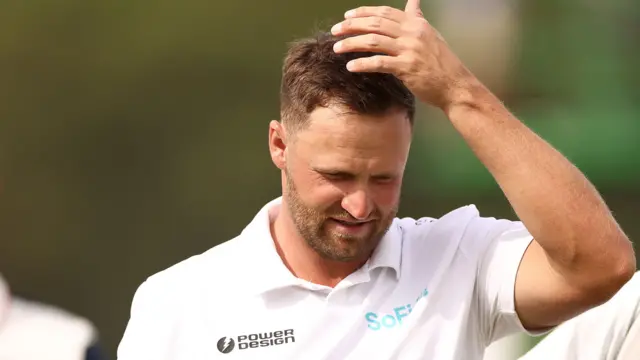 Wyndham Clark holds his head