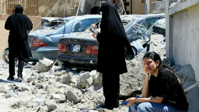 A Lebanese woman weeps as she sits on the rubble at the site of an Israeli airstrike in Qennarit, southern Lebanon, 20 June