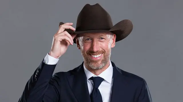 Graham Potter poses wearing a suit and Stetson