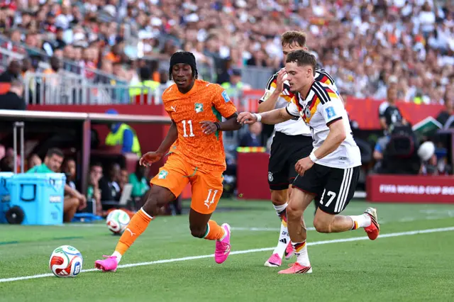 Yan Diomande controls the ball against Florian Wirtz
