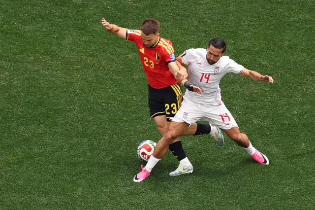 Nicolas Raskin and Iran's midfielder Saman Ghoddos fight for the ball