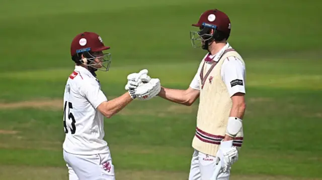 Thomas Rew (left) punches gloves with batting partner Craig Overton