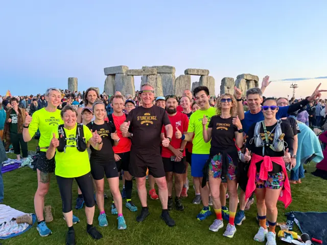 Stonehenge striders in front of stone circle
