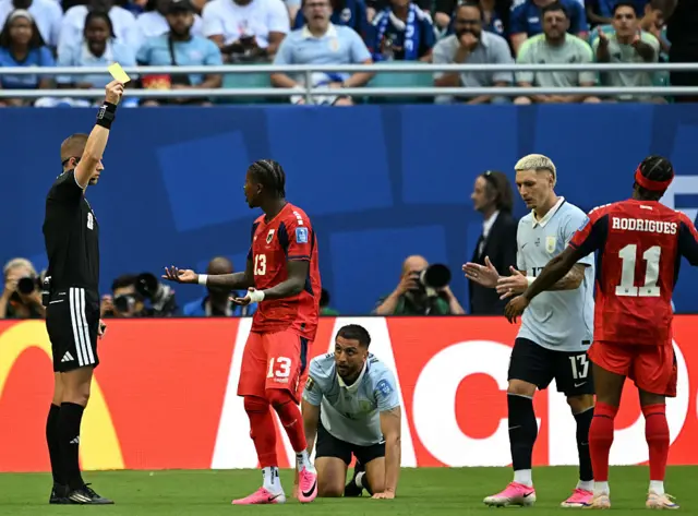 Norwegian referee Espen Eskas shows a yellow card to Cape Verde's defender #13 Sidney Lopes Cabral during the 2026 World Cup Group H football match between Uruguay and Cape Verde